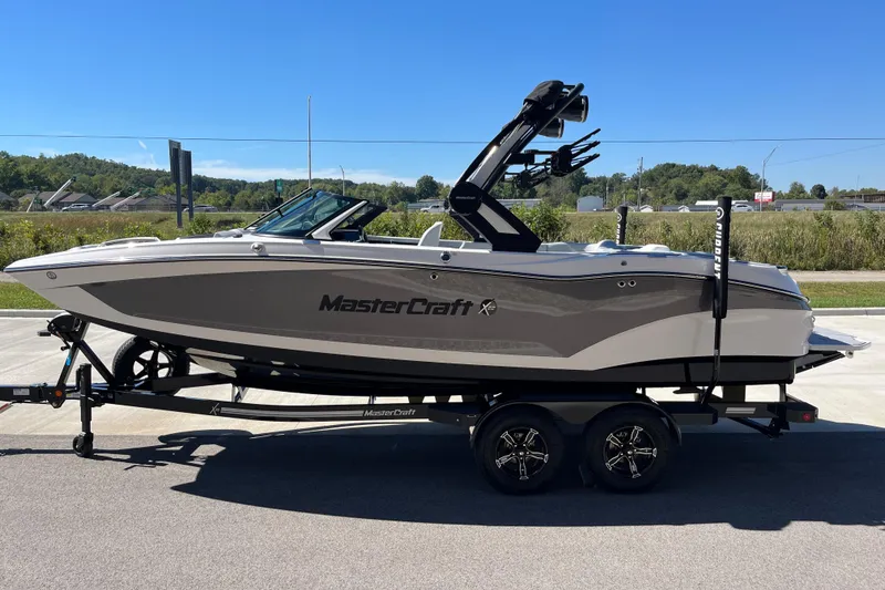 Slide: The Image of 2025 MasterCraft X22 boat on trailer, sleek design, parked outdoors. - 6