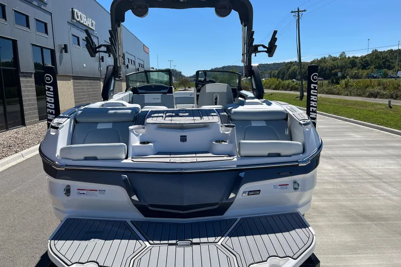 Slide: The Image of 2025 MasterCraft X22 boat, rear view, parked outdoors on a sunny day. - 9