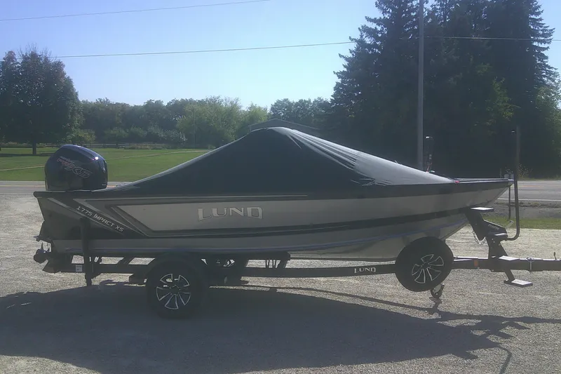 Slide: The Image of 2026 Lund 1775 Impact XS Sport boat on trailer, covered, parked outdoors. - 14