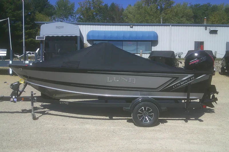 Slide: The Image of 2026 Lund 1775 Impact XS Sport boat on trailer, covered, parked outdoors. - 15