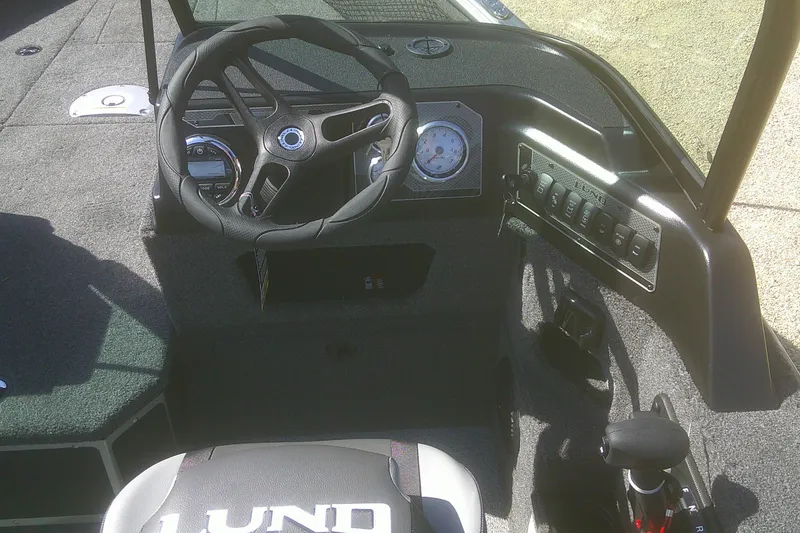 Slide: The Image of 2026 Lund 1775 Impact XS Sport boat interior with steering wheel and control panel. - 8