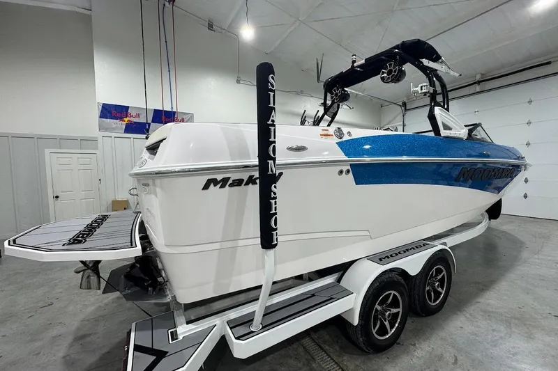 Slide: The Image of 2020 Moomba Makai boat in a garage, featuring a blue and white design on a trailer. - 5