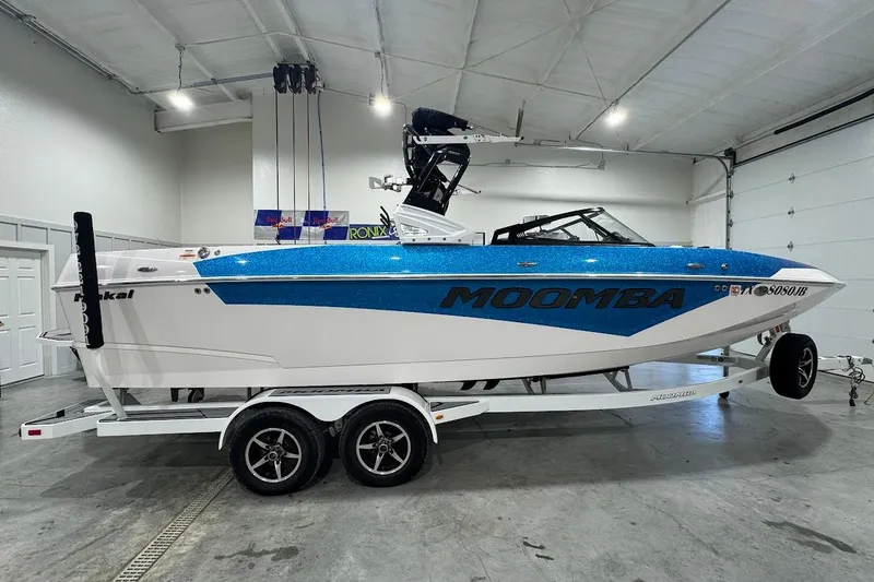 Slide: The Image of 2020 Moomba Makai boat in a garage, blue and white design on a trailer. - 6
