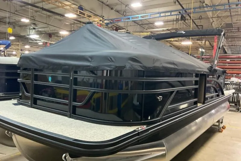 Slide: The Image of 2026 Bennington 22 SSRSE pontoon boat with black cover in a warehouse setting. - 12
