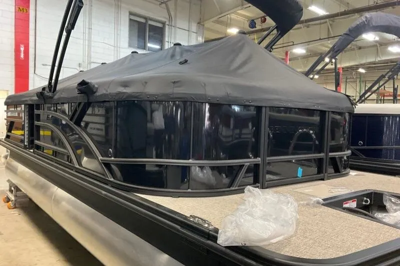 Slide: The Image of 2026 Bennington 22 SSRSE pontoon boat with black cover in a showroom. - 13