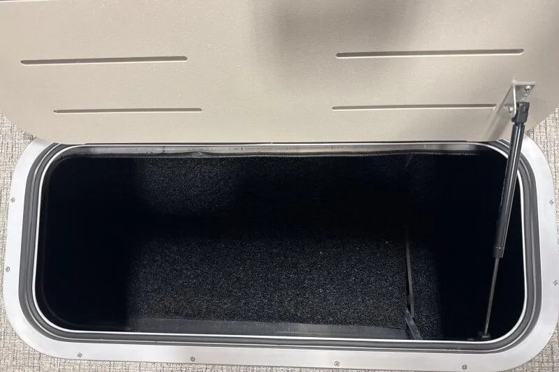 Slide: The Image of Open storage compartment in 2026 Bennington 22 SSRSE boat, featuring carpeted interior. - 16