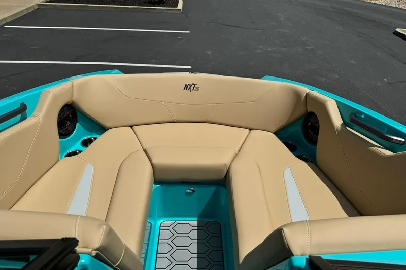 Slide: The Image of 2025 MasterCraft NXT20 boat interior with beige seating and teal accents. - 8