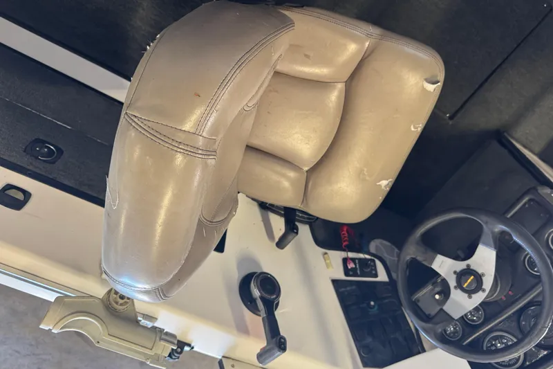 Slide: The Image of 1998 Skeeter WX1850 boat interior with worn leather seat and steering console. - 6