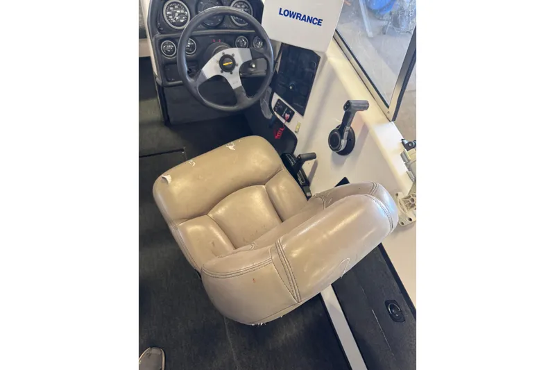 Slide: The Image of 1998 Skeeter WX1850 boat cockpit with steering wheel and worn beige seat. - 7