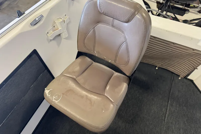 Slide: The Image of 1998 Skeeter WX1850 boat seat with beige upholstery and visible wear. - 9