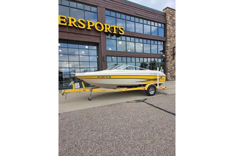 The Image of 2003 Glastron GX185SF boat on trailer outside a dealership. - 1