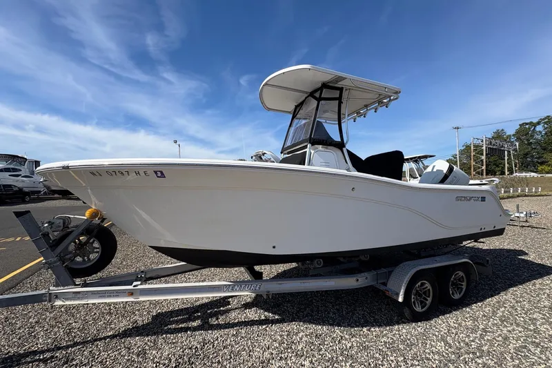 The Image of 2012 Sea Fox 226 Center Console boat on trailer, parked outdoors under clear sky. - 0