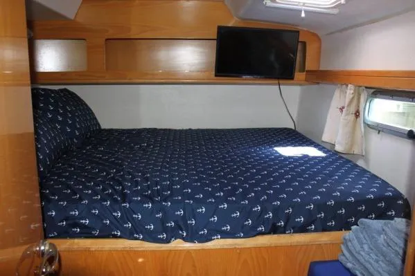 Slide: The Image of 2006 Alliaura Marine Privilege 435 EZC cabin with bed, TV, and nautical-themed bedding. - 23