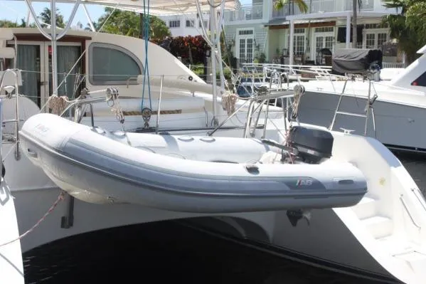 Slide: The Image of 2006 Alliaura Marine Privilege 435 EZC catamaran with dinghy, docked at marina. - 56