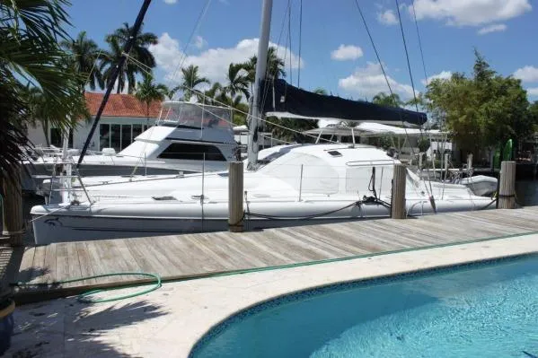 Slide: The Image of 2006 Alliaura Marine Privilege 435 EZC catamaran docked by a poolside, surrounded by palm trees. - 59