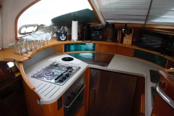 Slide: The Image of 2006 Alliaura Marine Privilege 435 EZC yacht kitchen with stove, fridge, and modern amenities. - 9