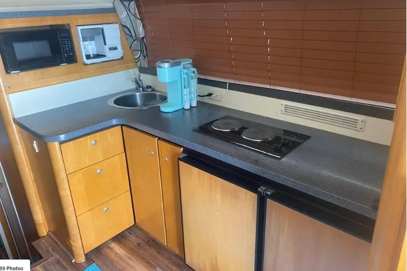 Slide: The Image of 2000 Luhrs Tournament 360 Convertible yacht kitchen with microwave, sink, and stove. - 17