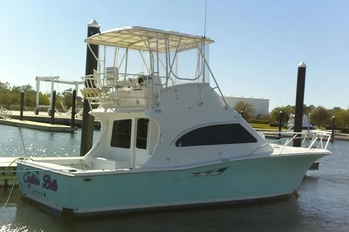 Slide: The Image of 2000 Luhrs Tournament 360 Convertible boat docked in a marina. - 2