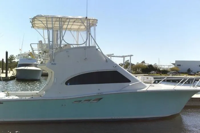 Slide: The Image of 2000 Luhrs Tournament 360 Convertible boat docked at marina, side view. - 3