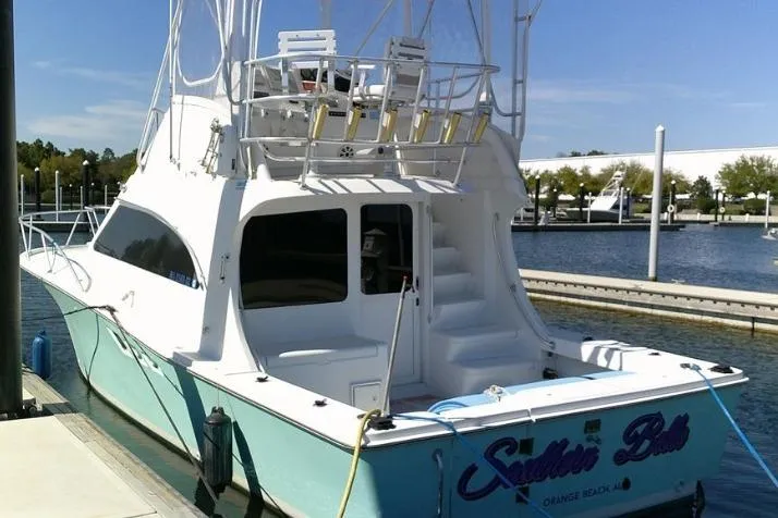 Slide: The Image of 2000 Luhrs Tournament 360 Convertible yacht docked at marina, featuring spacious deck and fishing equipment. - 5