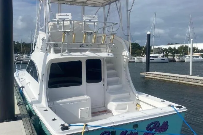 Slide: The Image of 2000 Luhrs Tournament 360 Convertible boat docked at marina, featuring spacious deck and flybridge. - 7