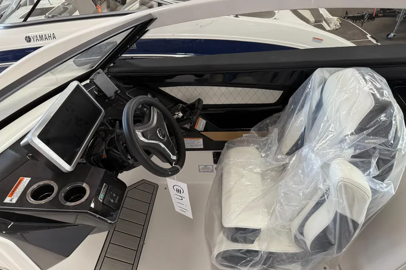 Slide: The Image of 2026 Yamaha Boats 275SD cockpit with steering wheel, touchscreen, and wrapped captain's chair. - 10