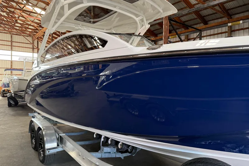 Slide: The Image of 2026 Yamaha Boats 275SD in a warehouse, showcasing sleek blue hull design. - 4