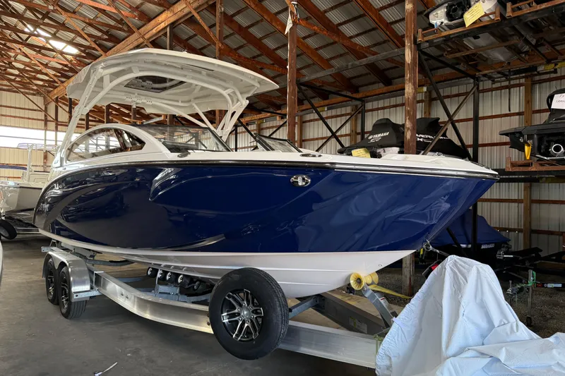 Slide: The Image of 2026 Yamaha Boats 275SD in storage, featuring sleek blue and white design. - 5