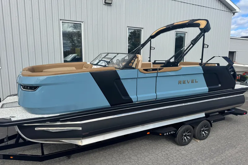 Slide: The Image of 2026 Revel RS25 boat on trailer, sleek design, blue and black color scheme. - 11