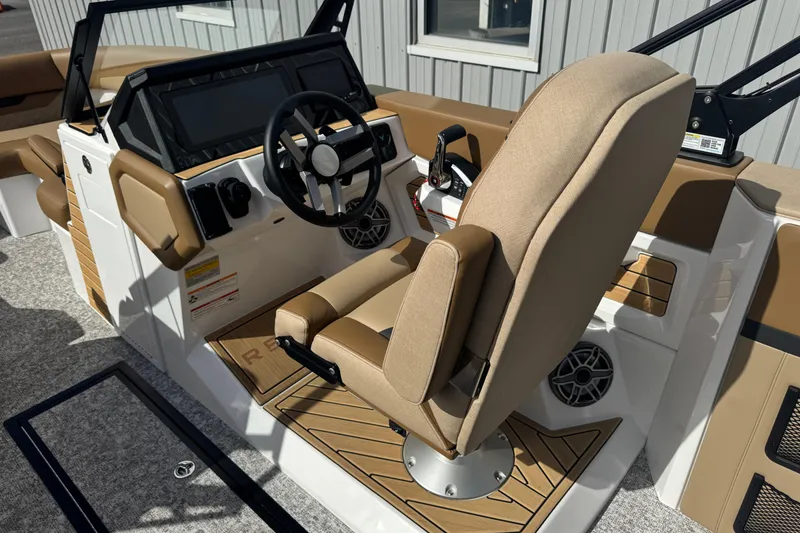 Slide: The Image of 2026 Revel RS25 boat interior with beige seating, steering wheel, and control panel. - 24
