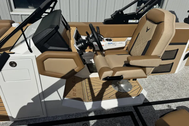 Slide: The Image of 2026 Revel RS25 boat cockpit with tan seating and modern steering console. - 25
