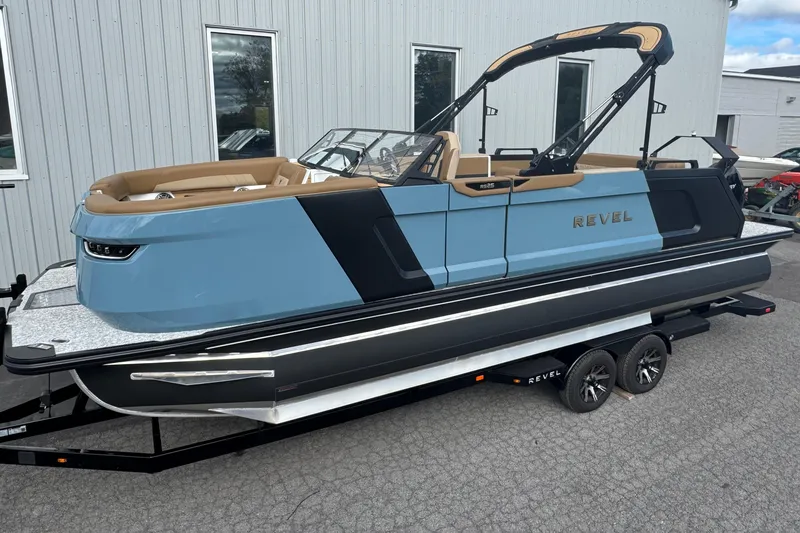 The Image of 2026 Revel RS25 boat on trailer, sleek design, blue and black color scheme. - 6