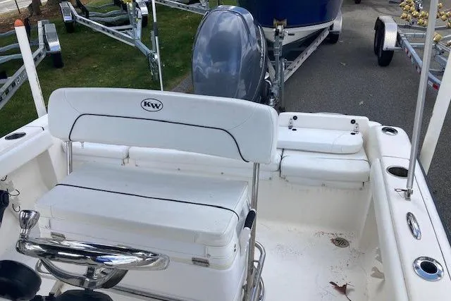 Slide: The Image of 2013 Key West 189 FS boat interior with seating and motor, parked on a trailer. - 10
