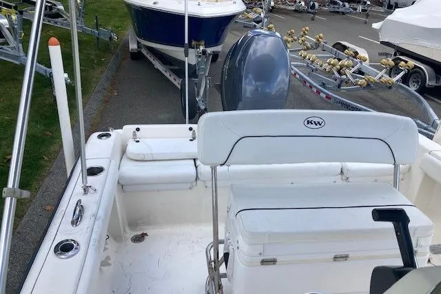 Slide: The Image of 2013 Key West 189 FS boat interior with seating and motor, parked on a trailer. - 9
