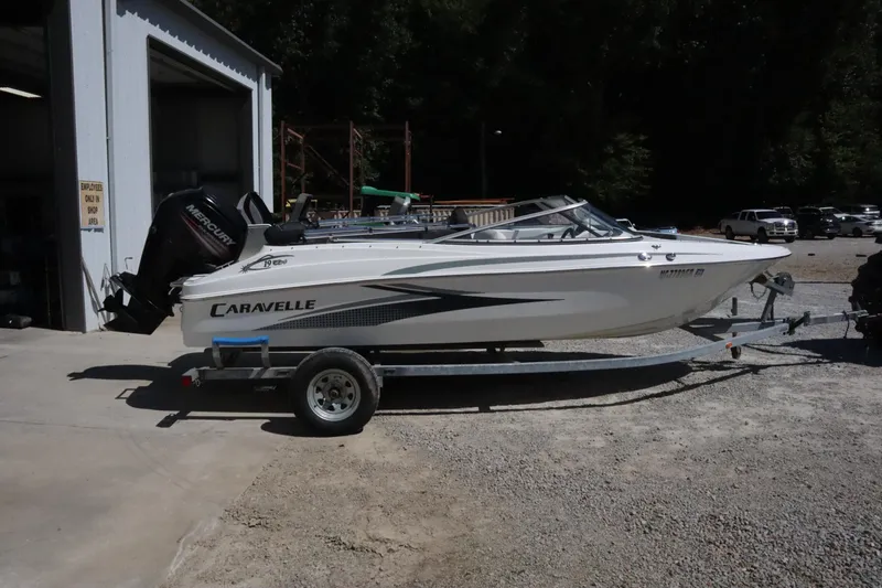 The Image of 2014 Caravelle 19 EBo Bowrider boat on trailer outside a garage. - 0