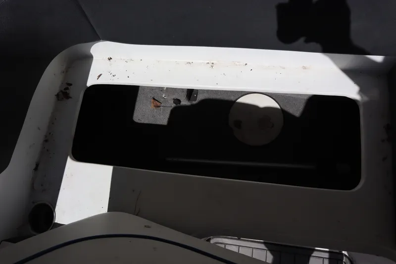 Slide: The Image of 2014 Caravelle 19 EBo Bowrider storage compartment with shadow and debris. - 18