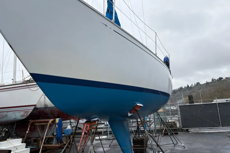 Slide: The Image of 1980 C&C 36 sailboat on dry dock, blue hull, overcast sky. - 27