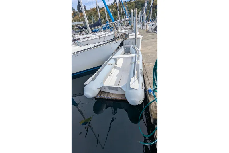 Slide: The Image of Inflatable dinghy docked beside a 1980 C&C 36 sailboat in a marina. - 29
