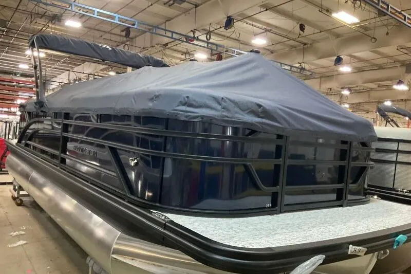 Slide: The Image of 2026 Bennington 23 SSRSF pontoon boat covered in a warehouse setting. - 11