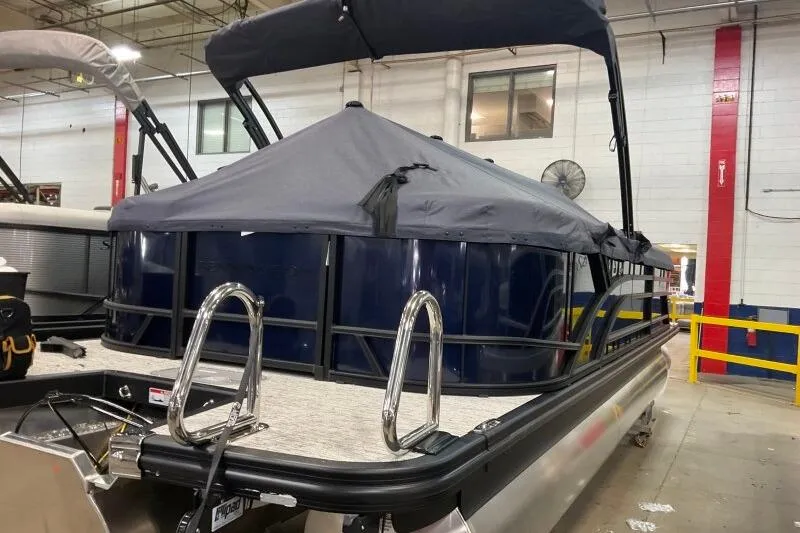 Slide: The Image of 2026 Bennington 23 SSRSF pontoon boat with cover in a warehouse setting. - 14