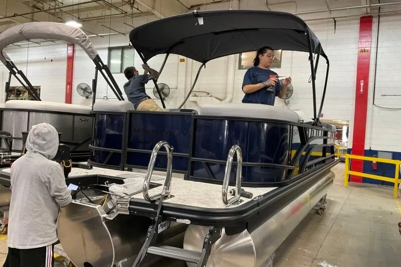 Slide: The Image of Workers assembling a 2026 Bennington 23 SSRSF pontoon boat in a factory setting. - 9