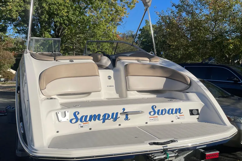 Slide: The Image of 2012 Yamaha AR240 HO boat with "Sampy's Swan" name, parked outdoors. - 3