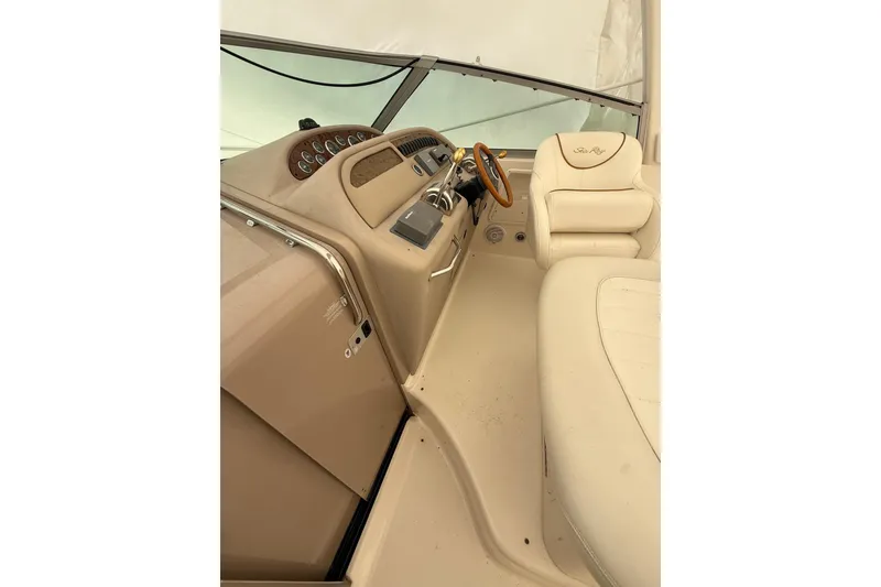 Slide: The Image of Interior of 2000 Sea Ray 310 Sundancer boat with beige seating and dashboard. - 12