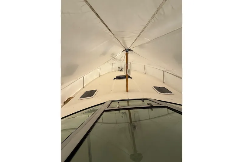 Slide: The Image of 2000 Sea Ray 310 Sundancer boat under protective cover, showcasing deck and hatches. - 14