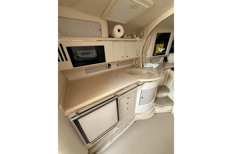 Slide: The Image of Interior of 2000 Sea Ray 310 Sundancer, featuring kitchenette with microwave and sink. - 19