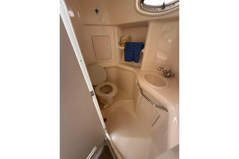 Slide: The Image of Compact bathroom in 2000 Sea Ray 310 Sundancer yacht, featuring toilet and sink. - 27