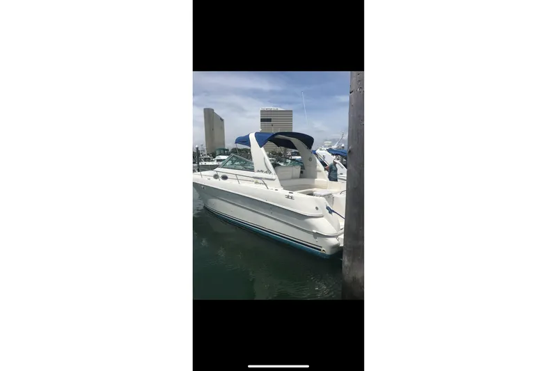 The Image of 2000 Sea Ray 310 Sundancer docked at marina, clear sky background. - 3