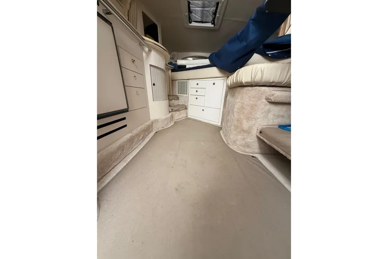 Slide: The Image of Interior of 2000 Sea Ray 310 Sundancer, featuring beige carpet and white cabinetry. - 30