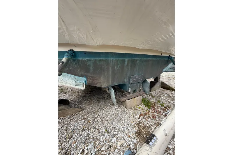 Slide: The Image of 2000 Sea Ray 310 Sundancer boat hull on gravel, supported by wooden blocks. - 36
