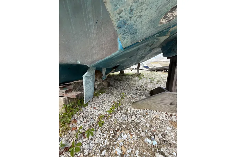 Slide: The Image of Underneath view of a 2000 Sea Ray 310 Sundancer boat on gravel. - 37